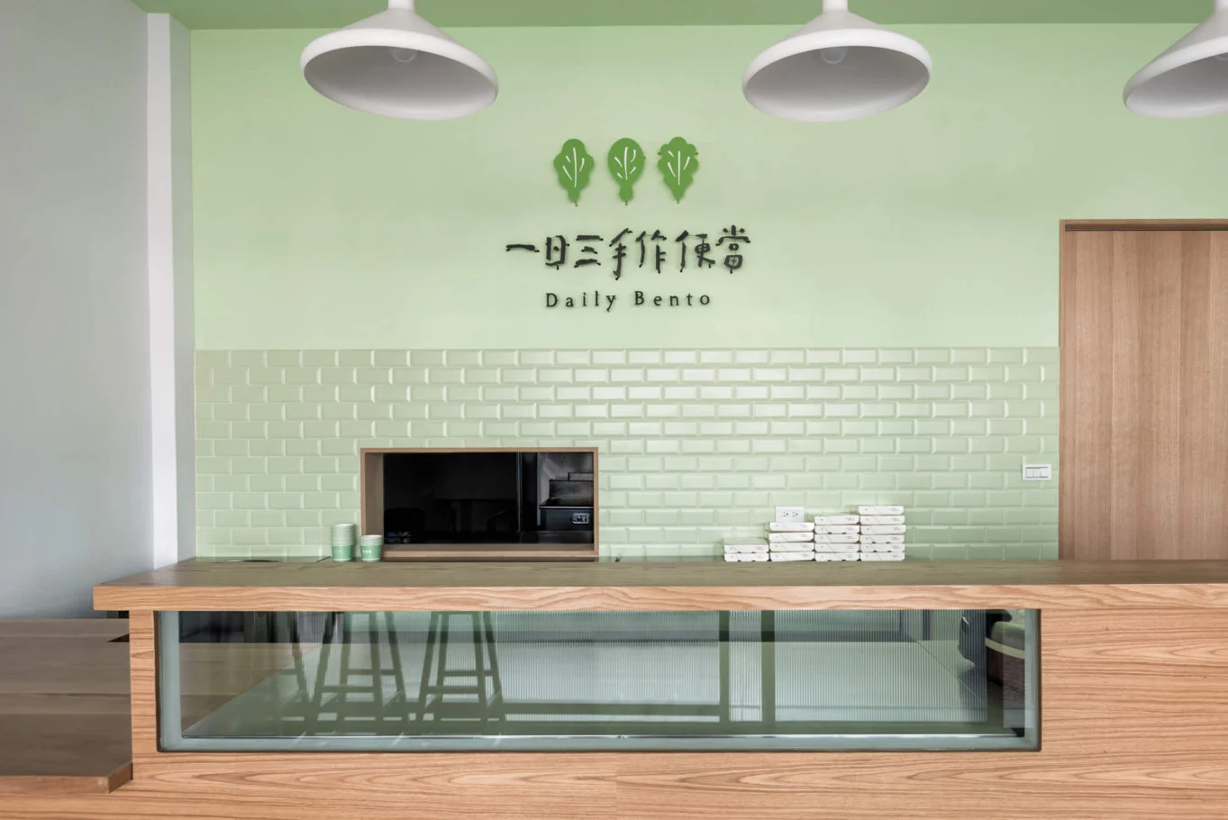 川彡志作・一日三手作｜展示櫃與綠色磚牆的正面視角