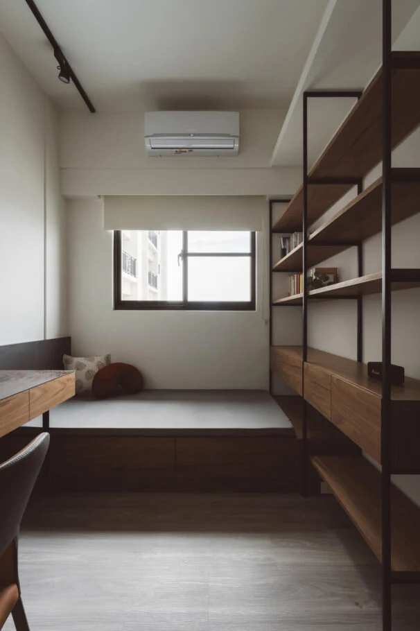 書房窗邊床榻、下方抽屜與黑色開放層架。