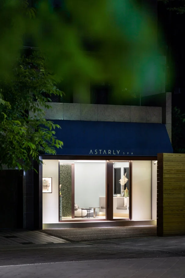 Astarly SPA｜植栽前景中的亮燈 SPA 門面