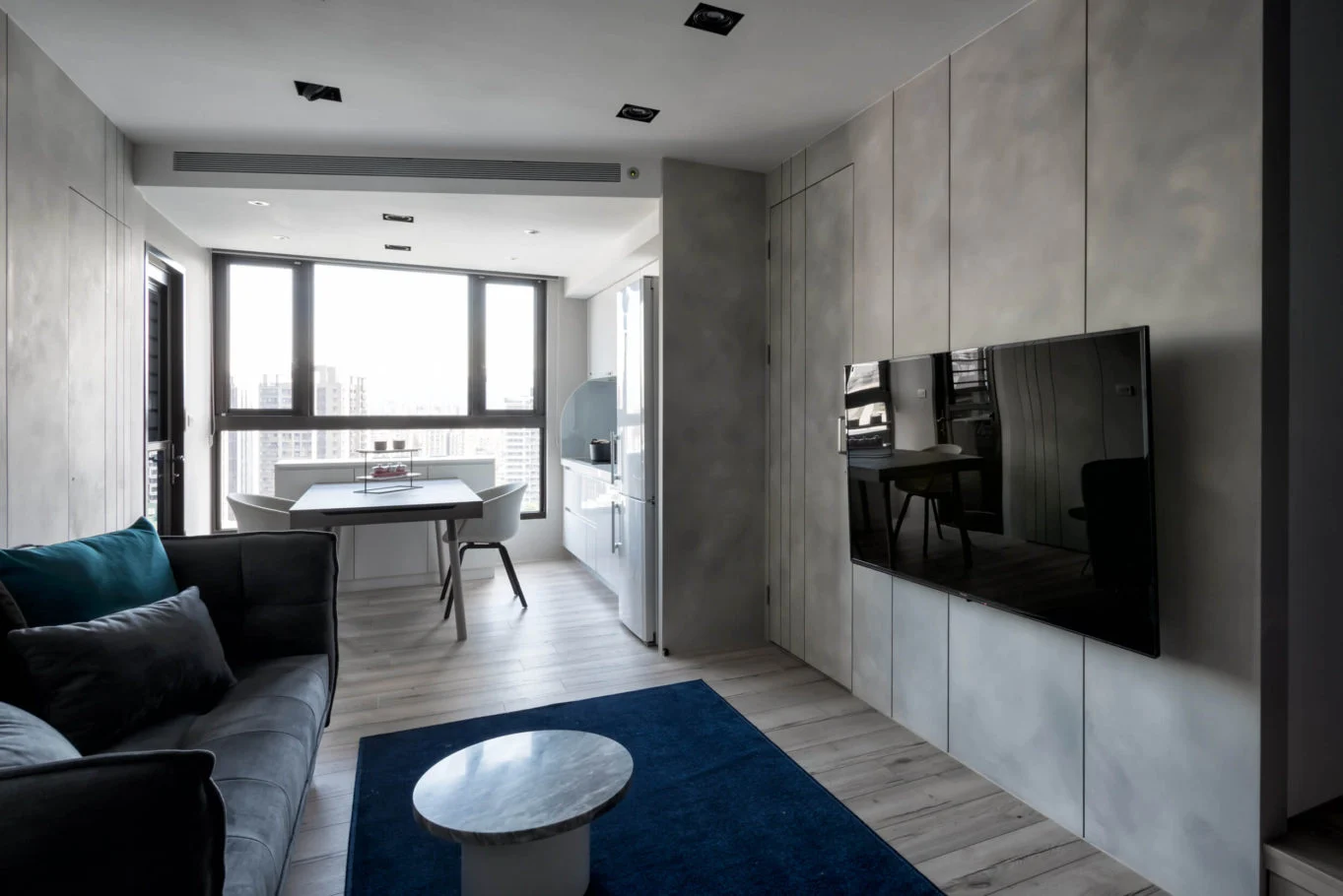 奇拓設計・樸玉|深灰沙發、藍色地毯與電視立面