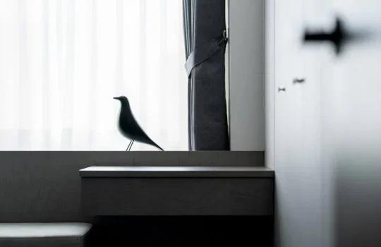 山冊設計・木質採光住宅｜窗邊鳥形擺飾、深色櫃面與窗簾